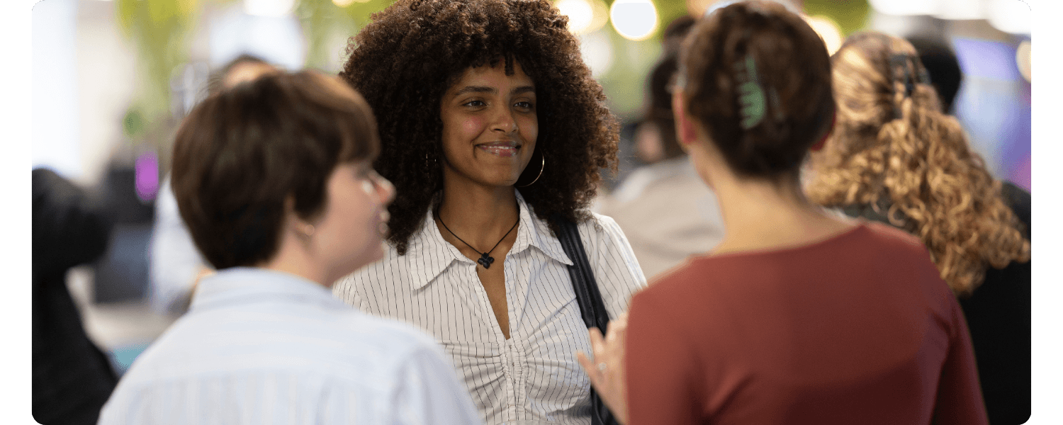 Three young women in a group smiling