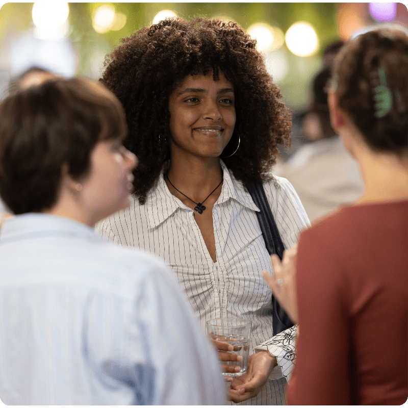 A group of three young women smiling at an event